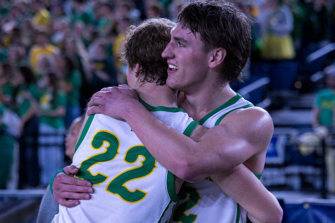 Richland’s Landen Northrop (12), right, embraces teammate Jackson Woodard (22) after the Bombers defeated Lake Washington 83-70 in the WIAA Class 4A boys state basketball semifinals Friday, March 6, 2026, at the Tacoma Dome. The win sends Richland to the state championship game Saturday.