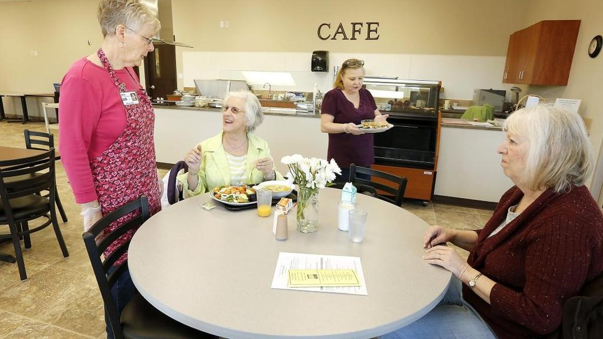 Volunteer Carol Charvet, left, and guest Joanne Gracio, of Richland, share a moment of conversation while cafe Manager Shannon Rhodes brings first-time visitor Lynn Price, of Richland, her soup and sandwich lunch at the Meals on Wheels Senior Dining Cafe in Richland.