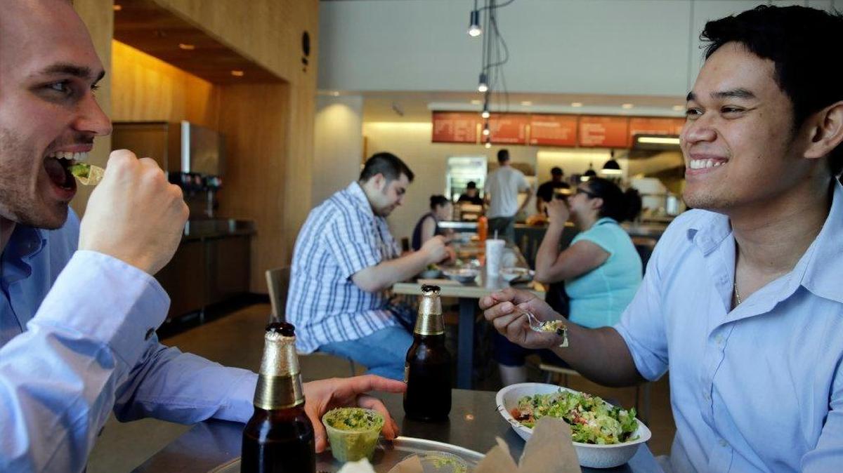 Tom Smurr, 24, and Charlie Chan, 27, from left, eat lunch at a Chipotle in Chicago earlier this year.