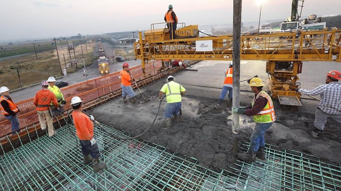 A Union Pacific train passes under the new overpass being constructed on Highway 124 about five miles east of Burbank before the sun rises Friday morning as construction workers pour the concrete deck. The deck pour for the $11 million project was delayed a couple weeks recently because of the high daily and overnight temperatures. The temperature of the concrete mix is important to its durability and strength, according to WSDOT officials. Monument Drive, which parallels the railroad tracks, is also being realigned so it connects to the highway farther west of the current location.