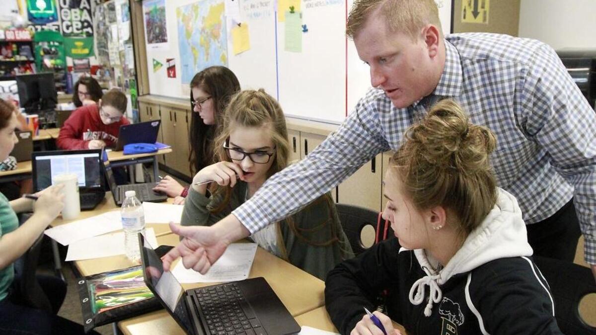 Teacher Nick White answers a question about an election-related assignment for seniors Kelsey Wallace, left, and Abreese Ungard during a U.S. government class this week at Richland High School.