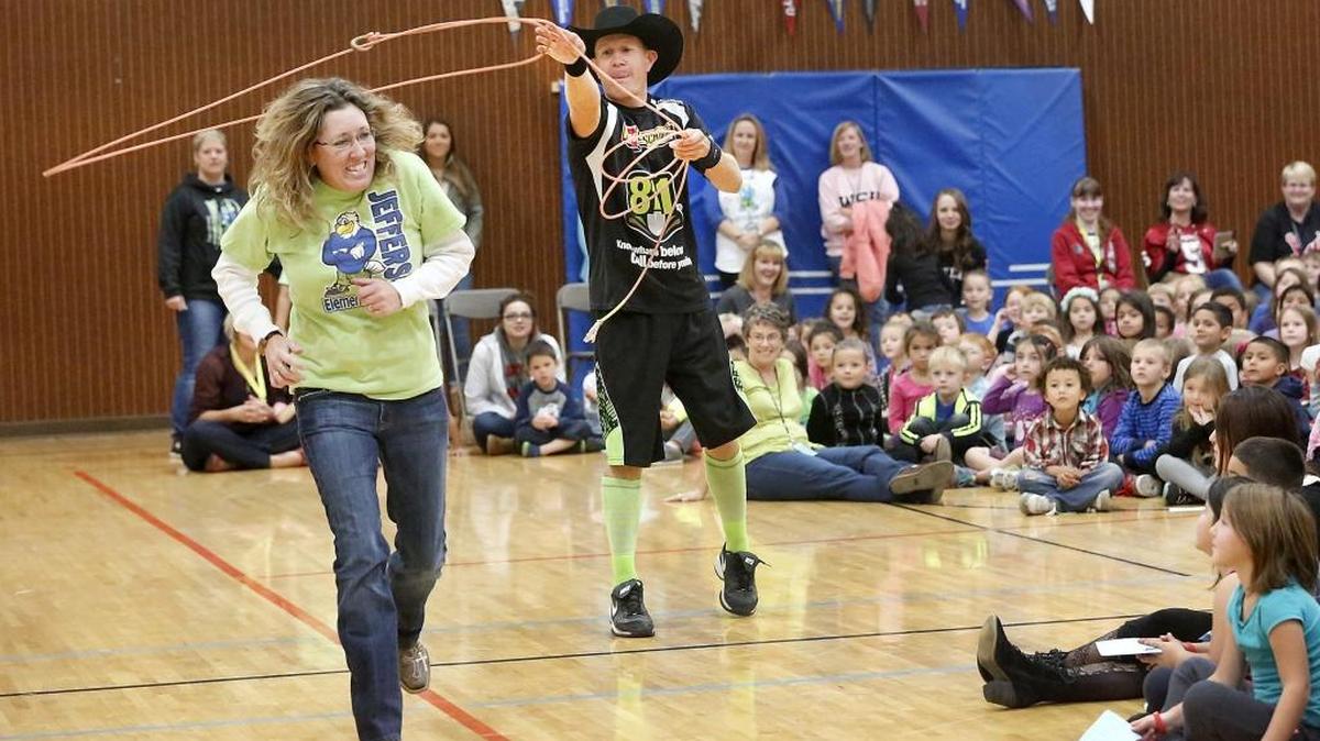 Jefferson Elementary administrative assistant Tina Burruss playfully runs from a rope thrown by JJ Harrison during his anti-bullying assembly Monday at the Richland school. About 550 students listened to the rodeo clown from Walla Walla, who can be found in the ring fighting bulls during the annual Benton Franklin Fair & Rodeo in Kennewick. Harrison, a former school teacher, challenged Burruss to outrun his lasso so students could get free ticket to this year’s fair. She didn’t get away but the students earned their tickets after answering questions about lessons they learned during the energetic presentation. Harrison will make the presentation Oct. 27 at Lincoln and Sunset View elementary schools in Kennewick.