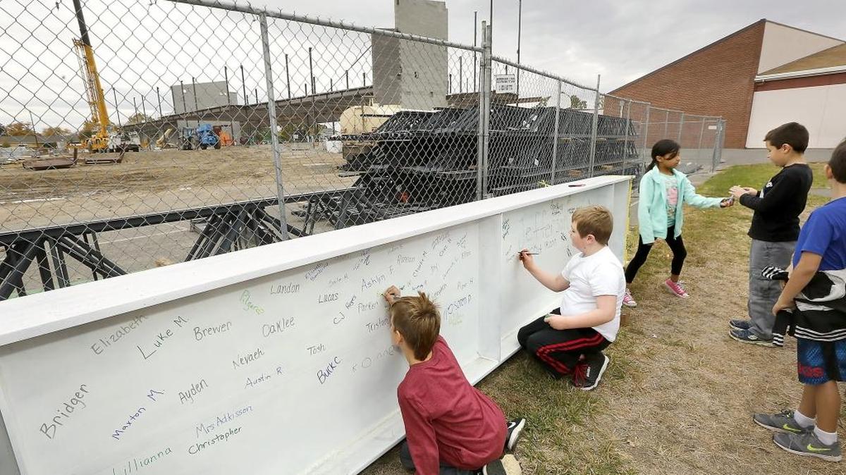 Students from Elizabeth Drane’s third-grade class take turns Wednesday signing their names on a steel beam for the new Jefferson Elementary School in Richland. The beam is scheduled to be lifted into place early next week. The 65,000-square-foot replacement school will house about 540 students.