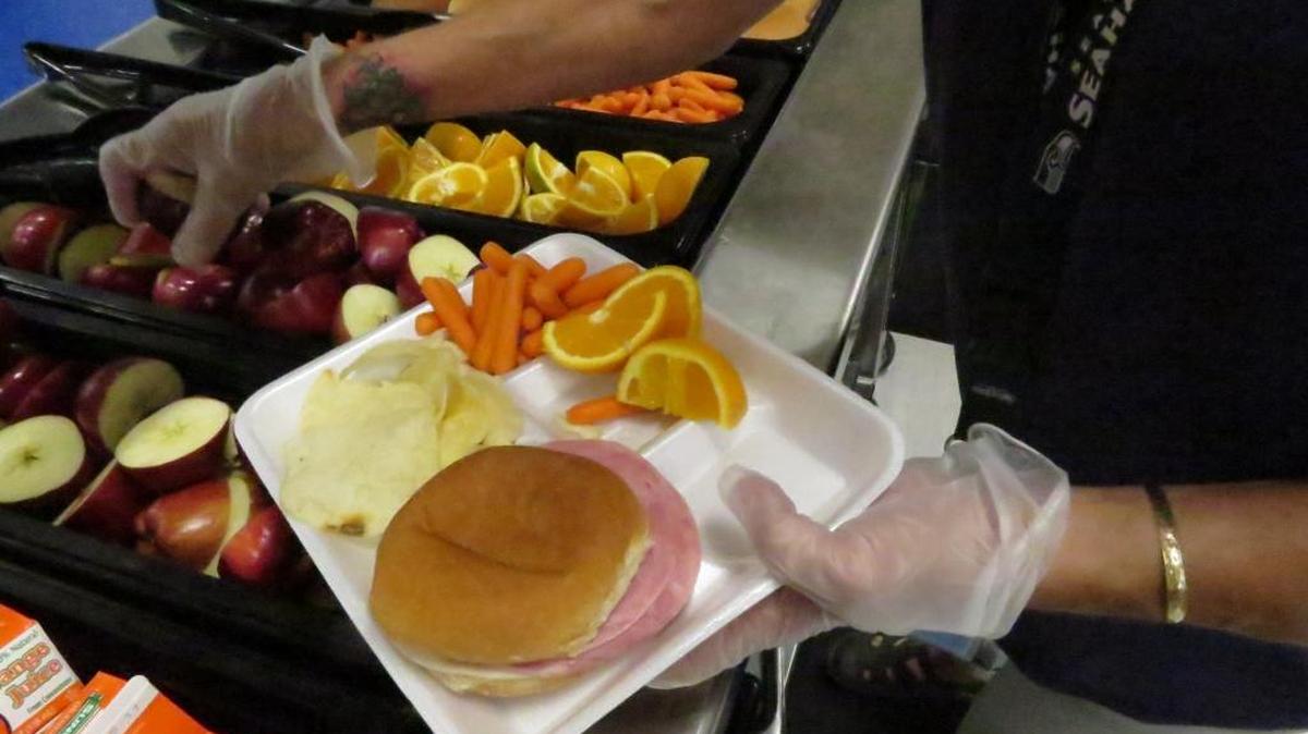 Cheryl Wilson, a field supervisor for Richland School District, serves a summer meal for a student.
