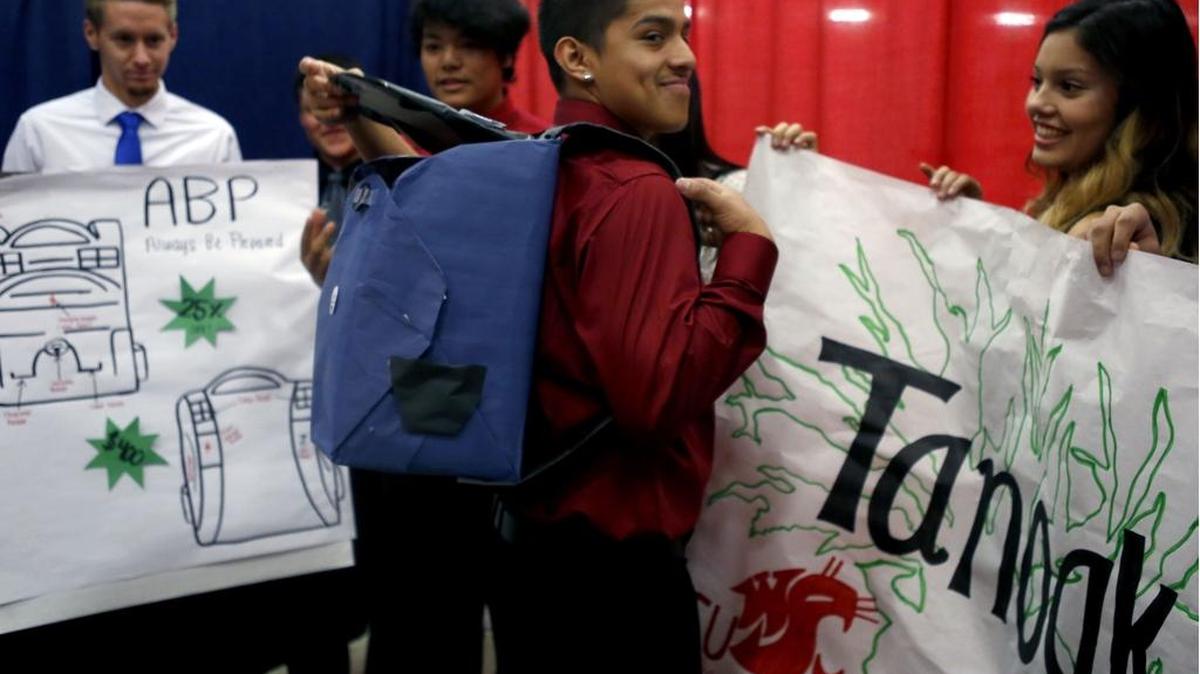 Juan Andrade, a Pasco High School senior, models the APB backpack invented by the fictional company — Tanoak — he created with other students in a presentation on Thursday during Enterprise Week at the TRAC in Pasco.