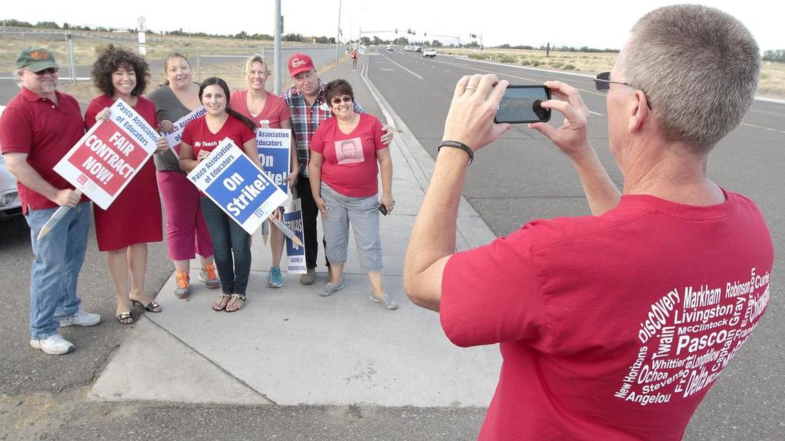 
Greg Olson, president of the Pasco Association of Educators, takes a group photo Wednesday of WEA president Kim Mead, second from left, with a group of picketing teachers at New Horizons School in Pasco.
