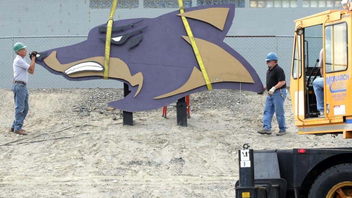 Columbia School District employees Pete Hollick, left, and Gary Jacobson work in 2012 at Burbank High School to install a new metal sculpture depicting the school mascot. District officials picked a new superintendent to replace Lou Gates.