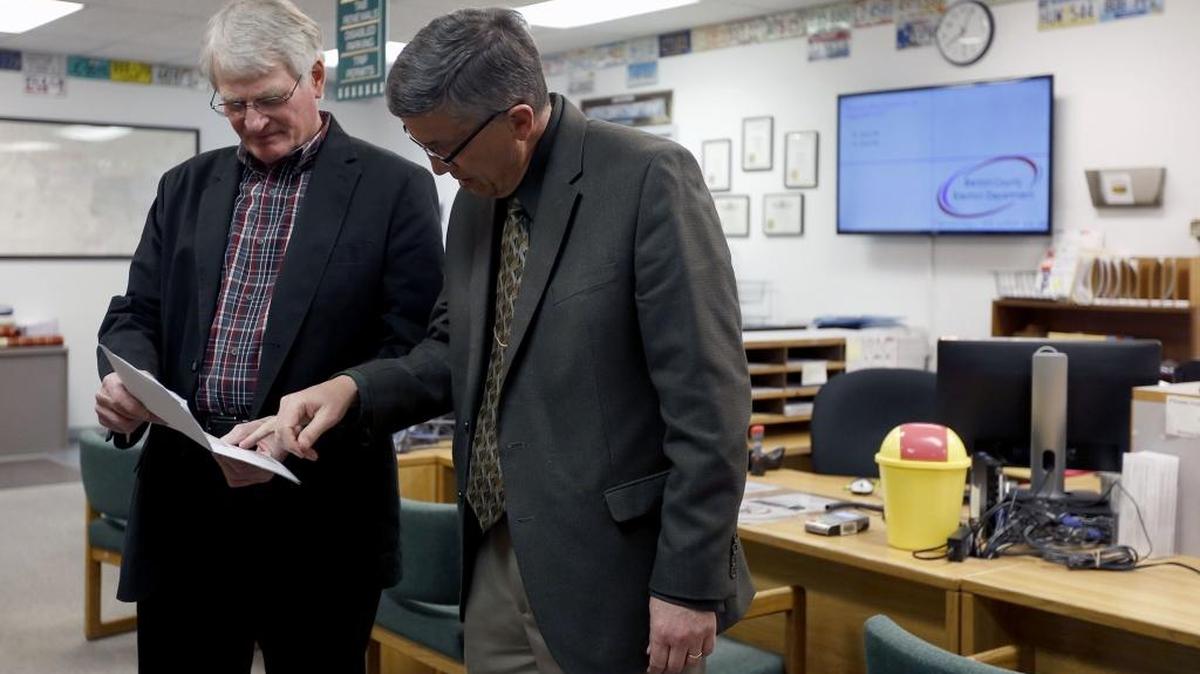 Kevin Veleke, left, chairman of the Kennewick Citizens’ Levy Committee, and Dave Bond, superintendent of the Kennewick School District, read over results for the district’s levy Tuesday at the Benton County Annex.