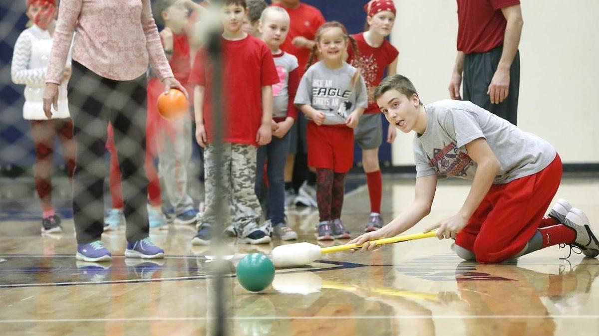Bryson Knapik, an eighth-grader at Bethlehem Lutheran School, drops low to improve his angle Friday during the hockey shoot event in the private school’s gymnasium. The event was part of the Kennewick school’s 31st annual Indoor Olympics program. Different teams of students, each comprised of students from each grade, competed in a variety of events, such as standing long jump, free throw, bowling, math and the hockey shoot. The students were also encouraged to dress in colorful clothes, paint their faces or hair to match their team’s colors.