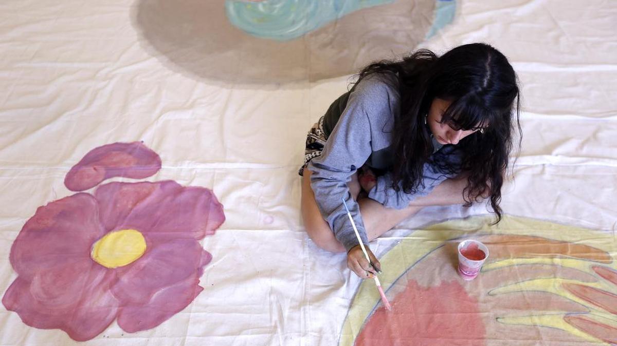 Cassidy Andryana Walker, 17 of Richland, works on a peace mural Tuesday at Washington State University Tri-Cities. The mural was created by young artists from the Urban Poets Society with guidance from participants in an art education workshop at WSU. It will be unveiled during a multicultural potluck open to the public at 5 p.m. July 21 at Howard Amon Park in Richland. See a video at www.tricityherald.com.