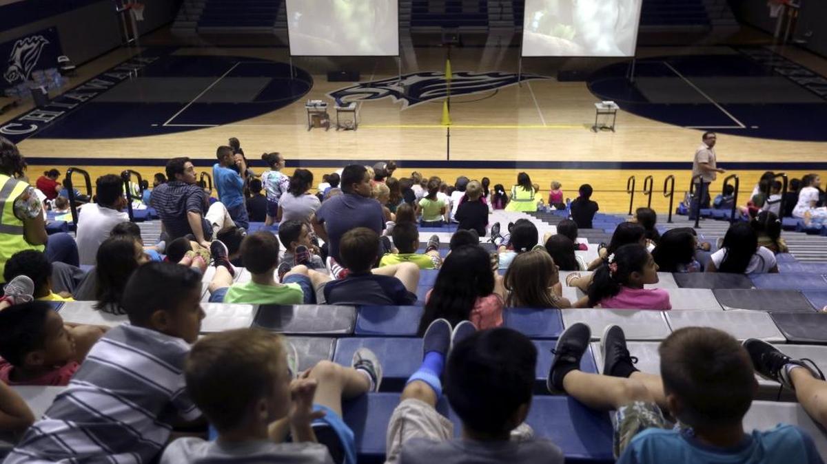 Students from Rosalind Franklin STEM Elementary watch a movie at the Chiawana High School gymnasium Tuesday after a problem with the air conditioning system forced 800 students to change schools. The 100-plus heat caused problems for schools and outdoor workers.