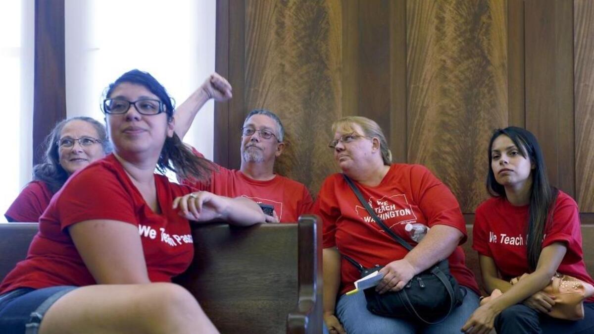 Pasco teacher Gerry Brazington cheers as he sits with Virgie Robinson Elementary co-workers, from right, Heather Merlo, Denise Barrera and Cindy Morris on Tuesday during a hearing on the Pasco School District injunction at the Franklin County Courthouse. Judge Ekstrom delayed enforcing sanction on Pasco Association of Educators though teachers continue to strike. The next hearing will be on Friday.