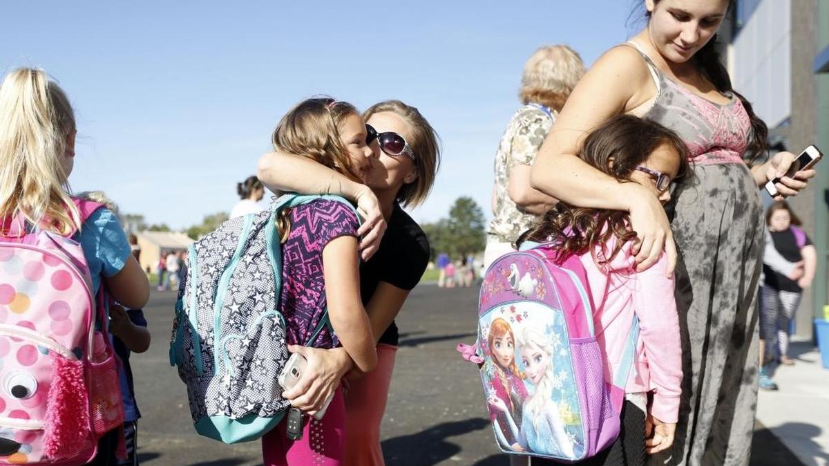 
Charity Daniel, center, kisses her daughter Carli Cook, 6, as Kelsey Cantor, right, hugs her daughter Tayanna, 6, Tuesday as they stand outside before the first day of school at the new Sacajawea Elementary School in Richland.
