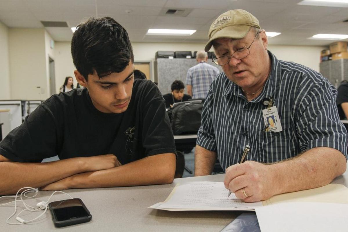 Alberto Contreras, left, a senior, gets some one-on-one help from math teacher Glen McNabb at New Horizon High School in Pasco. The school’s building is brand new.