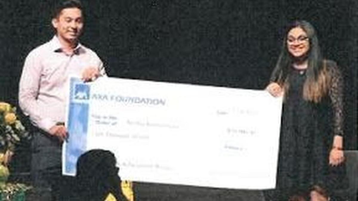 Swetha Shutthanandan, right, is awarded the AXA Scholarship by a representative.
