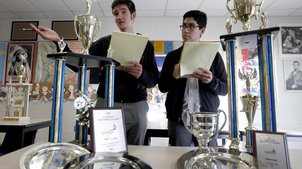 Lukas Garcia, right, looks on as teammate Charlie Landefeld presents an argument during forensics practice Tuesday at Southridge High School. They’re standing with recent trophies they’ve won.