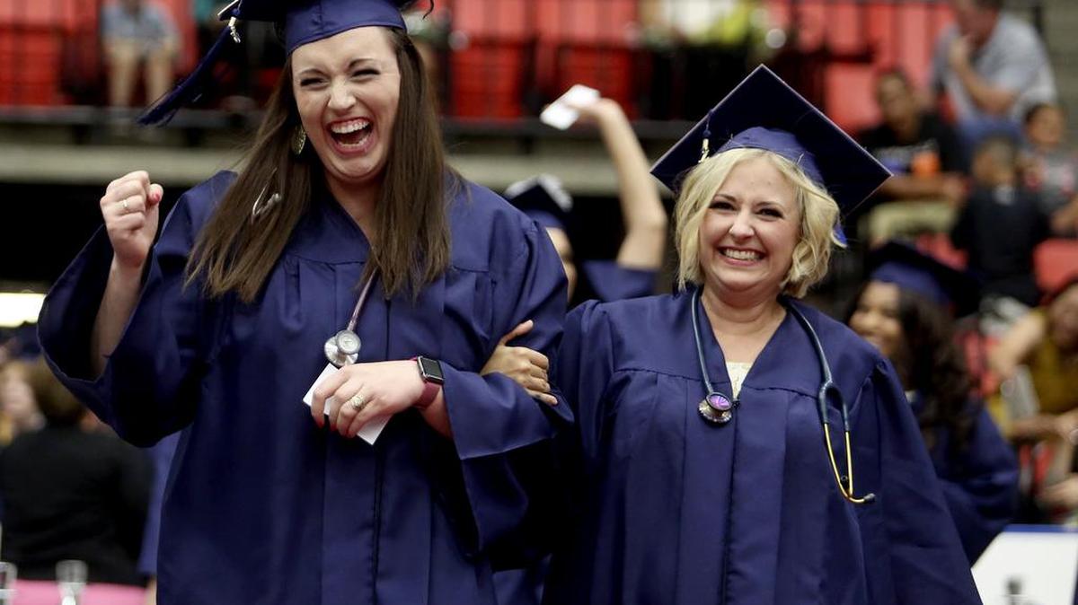 Nursing school graduates Molli Reiten, left, and Jennifer Holzer cheer as they walk to their seats Friday during Columbia Basin College's commencement ceremony at the Toyota Center in Kennewick. A record 1,453 degrees and certificates were awarded during the 60th annual graduation.