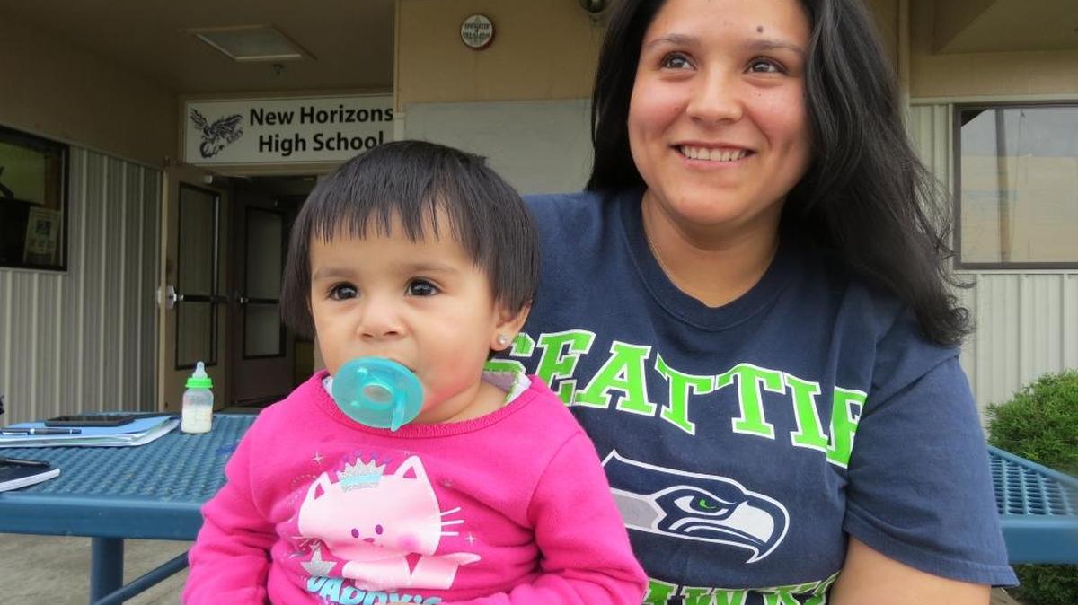 Ana Chavez holds her daughter outside of New Horizons High School in Pasco.