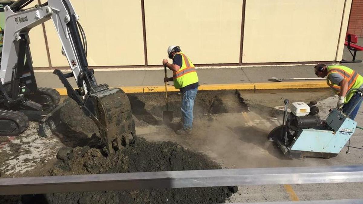 A crew with the city of Prosser works to figure out where a flood of water came from in an alley next to Prosser High School. The work has required water to the main school to be shut off but classes are continuing.