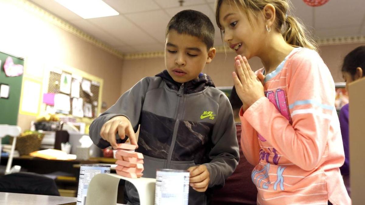 Fourth-grader Hannah Rameriz, right, looks on as Jesus Zuniga balances erasers on a bridge made of paper Thursday during STEM Story Day at Finley Elementary School. All students spent the day participating in activities that connected literature with STEM — science, technology, engineering and math — activities during the annual event. See a video at www.tricityherald.com/video.
