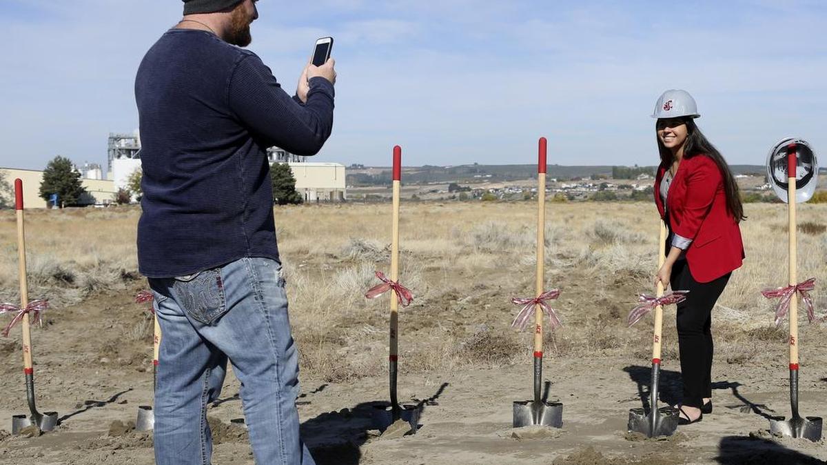 Shawn LaFortune takes a photo of Irsaa Aishaikhli, student body president, as she picks up a shovel Wednesday during a groundbreaking ceremony for WSU Tri-Cities new student housing project. See a video at www.tricityherald.com.