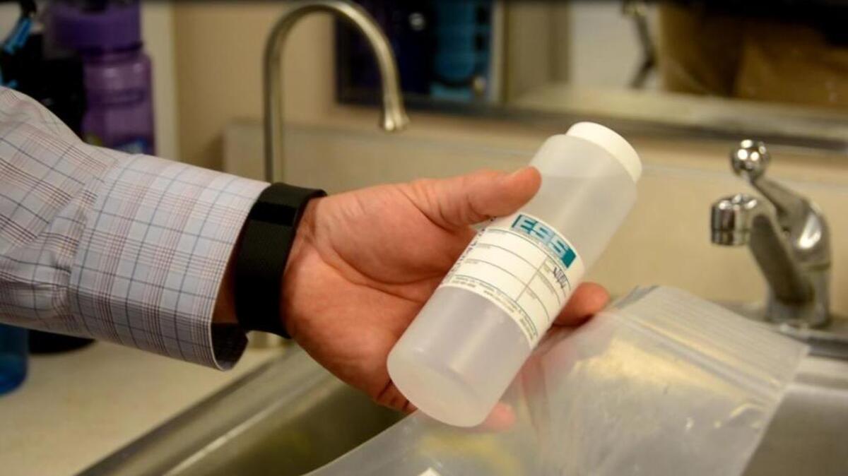 Ryan Mathews, of Fulcrum Environmental Consulting, demonstrates how water is sampled.