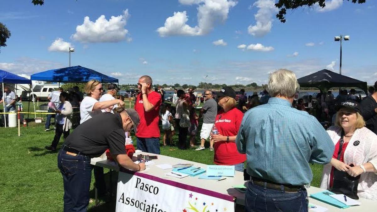 
Pasco Association of Educators President Greg Olson (left, in red shirt) speaks with supporters at Monday’s Labor Day Picnic at Columbia Park in Kennewick.
