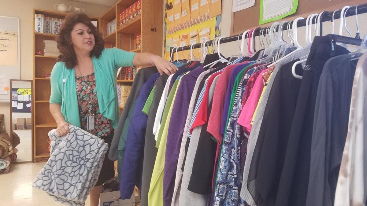 Paulina Valdez, the site coordinator for River’s Edge High School in Richland, stocks clothes in her office.