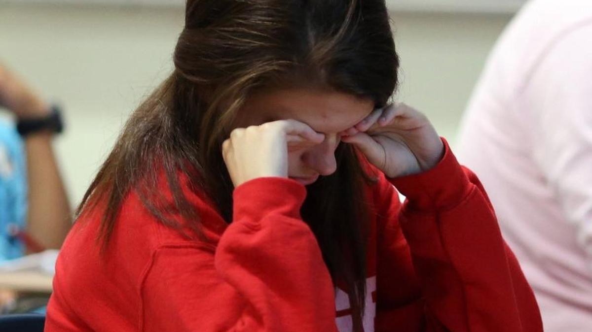 A high school junior rubs her face to stay awake during an honors physics class. The American Academy of Pediatrics says school start times should be pushed to 8:30 a.m. or later, as many students aren’t getting enough sleep.
