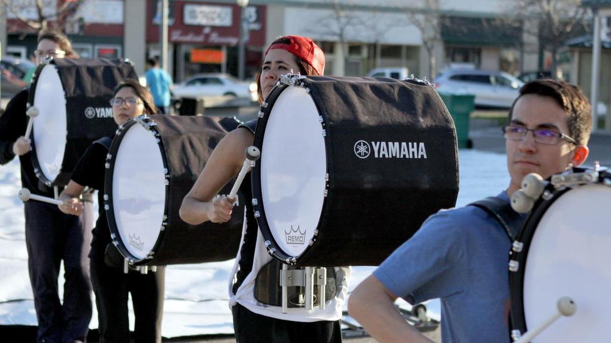 Bass drummers with winter percussion group Impact warm up ahead of rehearsal in the plaza of downtown Kennewick. The 20-plus member group has rehearsed outside throughout the winter.