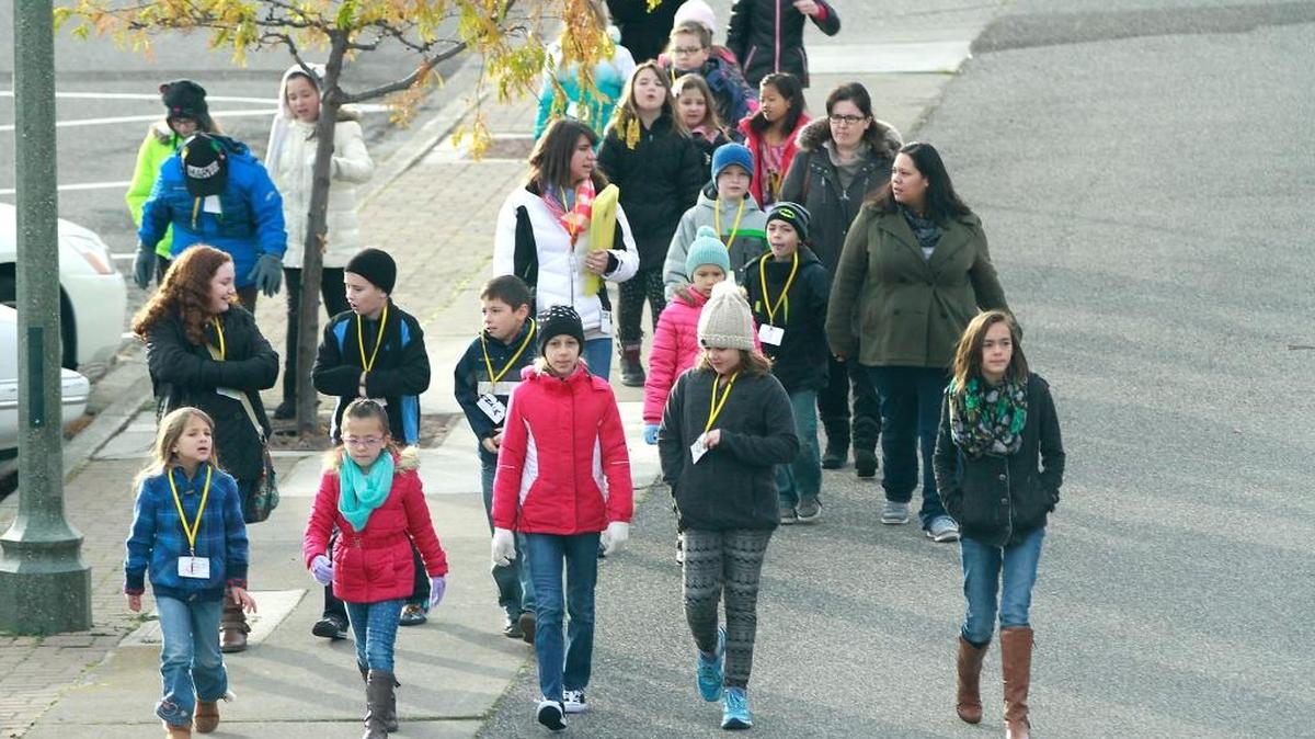 A group of students from the Mid-Columbia Partnership walk through downtown Kennewick Monday morning on their way to take a tour of the Tri-City Herald building.