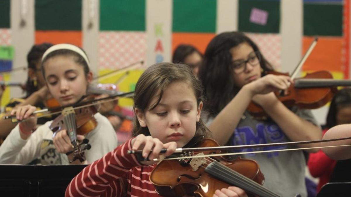 Eliana Spencer, a sixth-grader at Richland’s Carmichael Middle School, tunes her violin along with other students at the beginning of orchestra class. Fine arts programs such as music are among those largely funded by maintenance and operation levies up for renewal in many Mid-Columbia school districts in February.