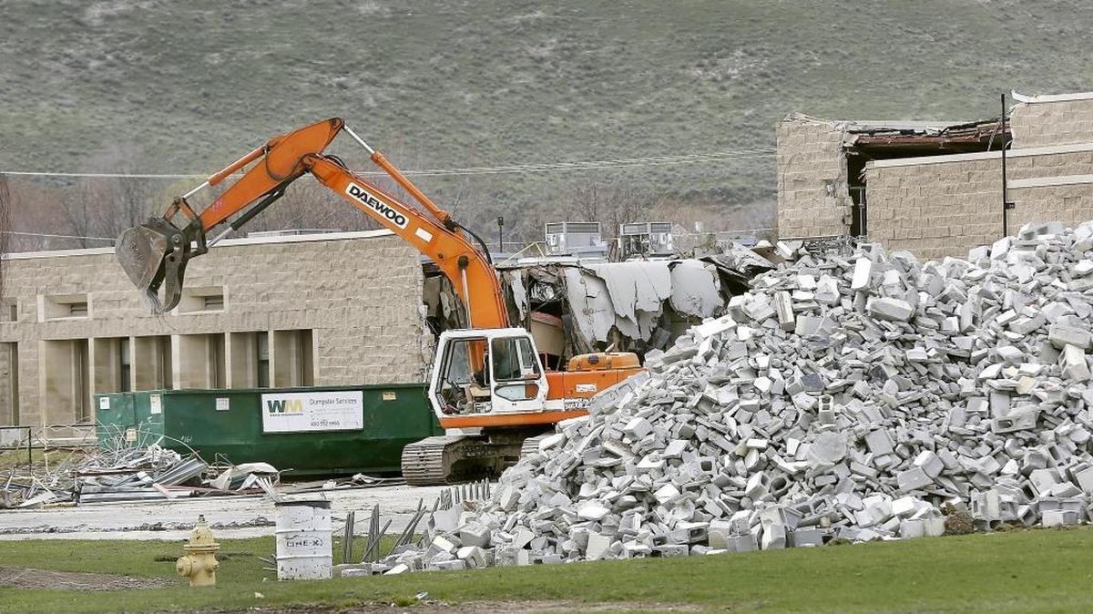 An excavator picks through debris in March near a large pile of concrete blocks from the demolition of the former Desert Hill Middle School campus. The Kennewick school board recently approved a $16.5 million bid from Richland-based Fowler General Construction to build a new 30-classroom, dual language elementary school at the site.