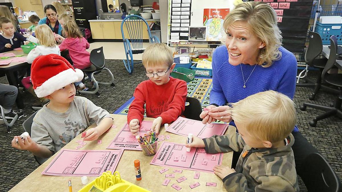 Paraeducator Karen McLaughlin helps kindergarten students at Lincoln Elementary School in Kennewick with a classroom exercise designed to help them learn words by sounding them out. From left: Brian Hall, Zack Scheib and Joey Hanning.