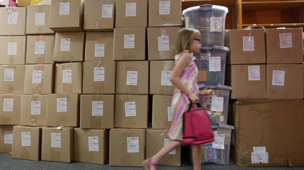 A second-grader walks past boxes in a classroom on the last day of school at Richland’s Marcus Whitman Elementary School in June 2015.