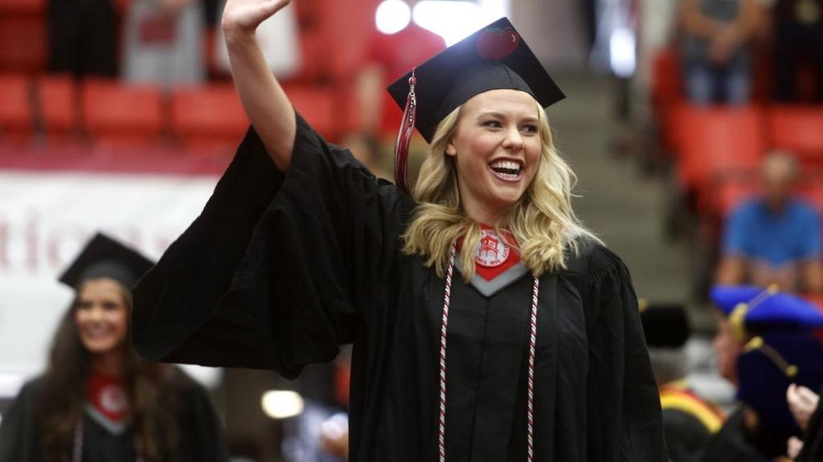 College of Education graduate Kaylee Boffey, of Richland, waves to friends and family Saturday during the WSU Tri-Cities Commencement program at the Toyota Center in Kennewick. See more photos at ww.tricityherald.com.