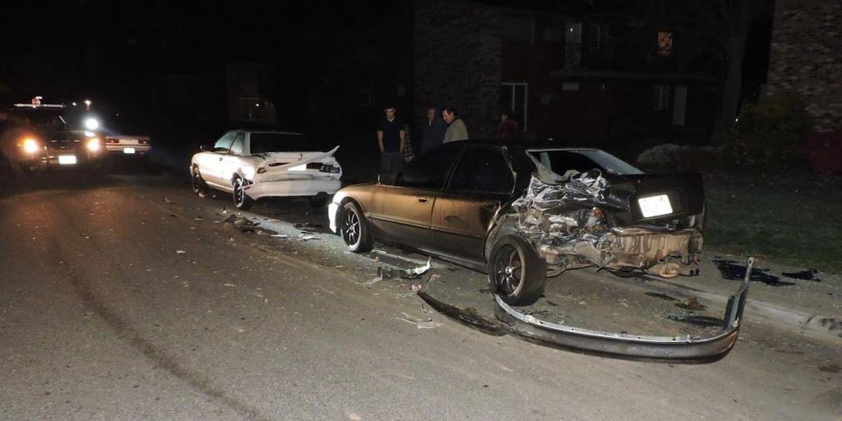 Police examine the two cars hit by the pickup.
