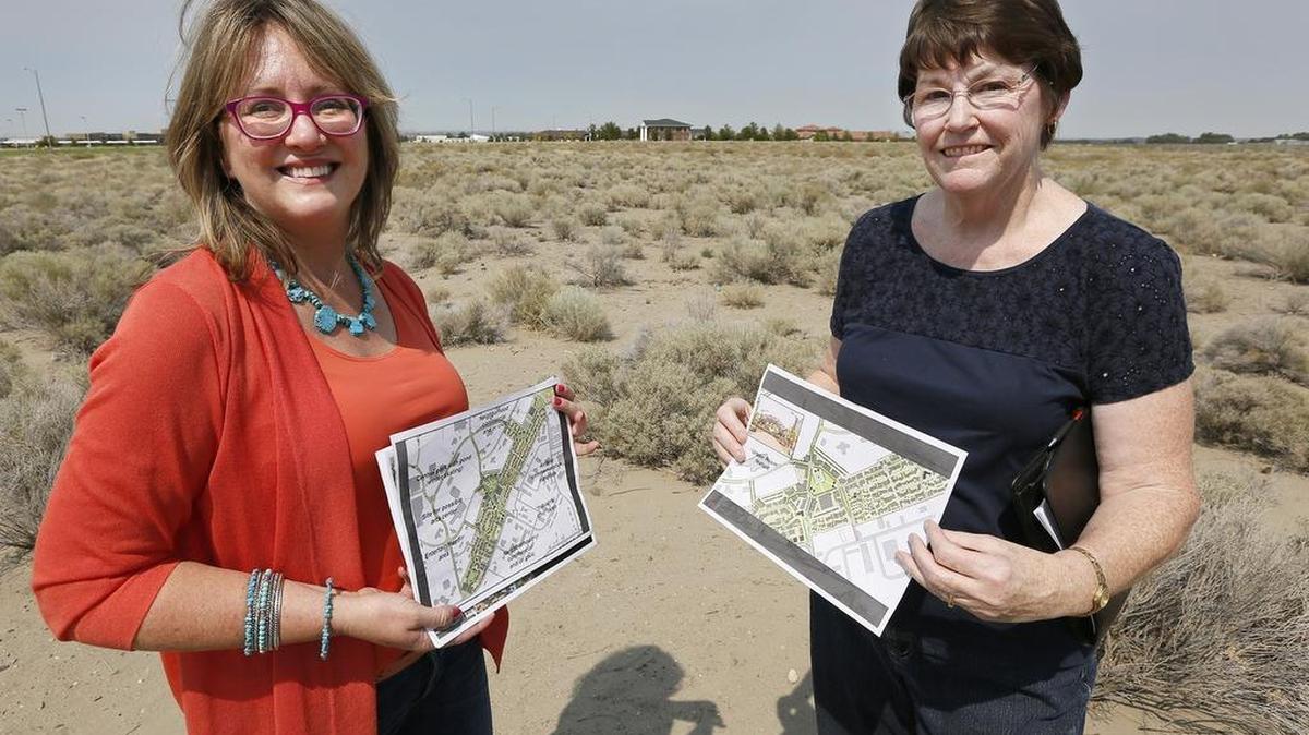 File photo: Tana Bader Inglima, left, of the Port of Kennewick, and Kathryn Lang, of the Arts Center Task Force, hold up renderings of the proposed arts center at Vista Field that would be built behind them.