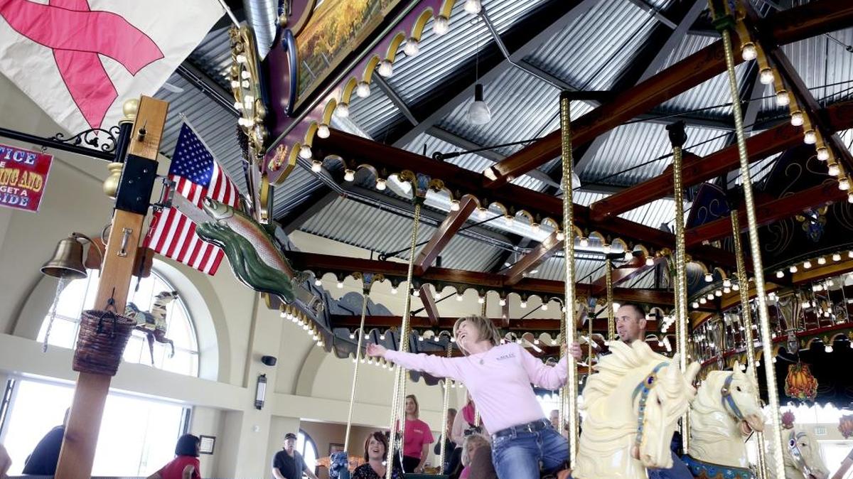 Tiffany Flager tries to grab the brass ring Friday at the Gesa Carousel of Dream to kick off Breast Cancer Awareness Month. Pink flags were raised in honor of the month at Kadlec Regional Medical Center in Richland and the carousel in Kennewick. Every time the carousel starts in October, $1 will be donated to Kadlec’s mammogram fund to help uninsured and under-insured women. See a video at www.tricityherald.com/video.