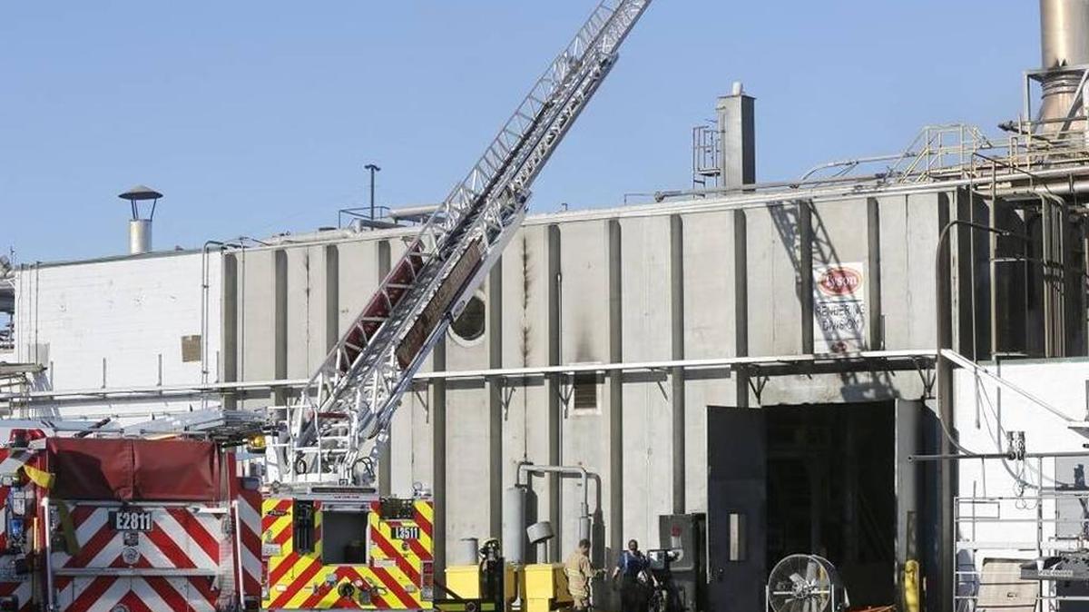 Firefighters walk past several fire trucks from area departments Tuesday morning near the rendering division section of the Tyson Foods plant on Dodd Road near Burbank. The production line at the beef processing facility is temporarily halted because of an early morning fire in the building. No one was injured.