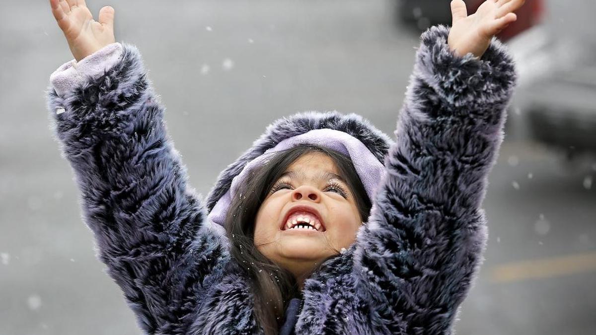 Audrina Lopez, 4, pauses while walking through a Kennewick parking lot Friday afternoon to try catching snowflakes that had started falling. She was with her parents Irma and Mike Lopez of Kennewick. “She’s hoping for enough to build a snowman,” said her mother. One to two inches of snow are possible on the ground by Christmas Eve.
