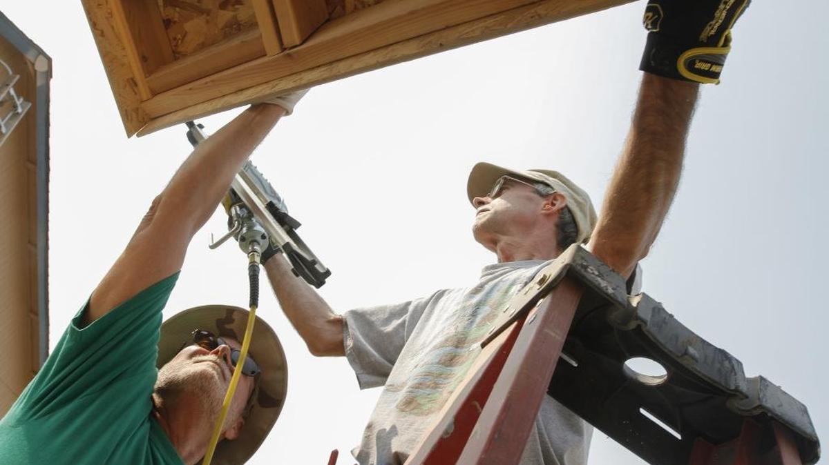 Bob Watkins, left, hold a piece of wood in place as Steve Brandt uses a nail gun to drive the nails into wood for a Habitat for Humanity home in Pasco. Watkins is from Richland and has been volunteering with Habitat For Humanity for two years, and Brandt of Richland has been volunteering with the group for a month.