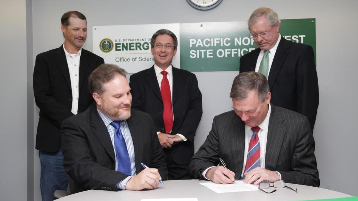 Battelle CEO Jeff Wadsworth signs a contract Tuesday for the company to operate PNNL for another five years. Looking on are Roger Snyder, manager of DOE’s Pacific Northwest Site Office (sitting), Ryan Kilbury, DOE’s Pacific Northwest Site Office contracting officer (standing, left), PNNL Director Steven Ashby (standing, middle) and Battelle Executive Vice President Ron Townsend.