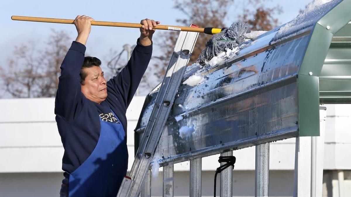 Xavier Munoz, an employee at Super 1 Tacos, uses a mop Friday morning to remove ice encrusted snow from the taco truck’s covered seating area at the corner of Aaron and Goethals Drives in Richland. Munoz said he didn’t want the icy chunks sliding off the metal roof and hitting customers as the day warmed up.