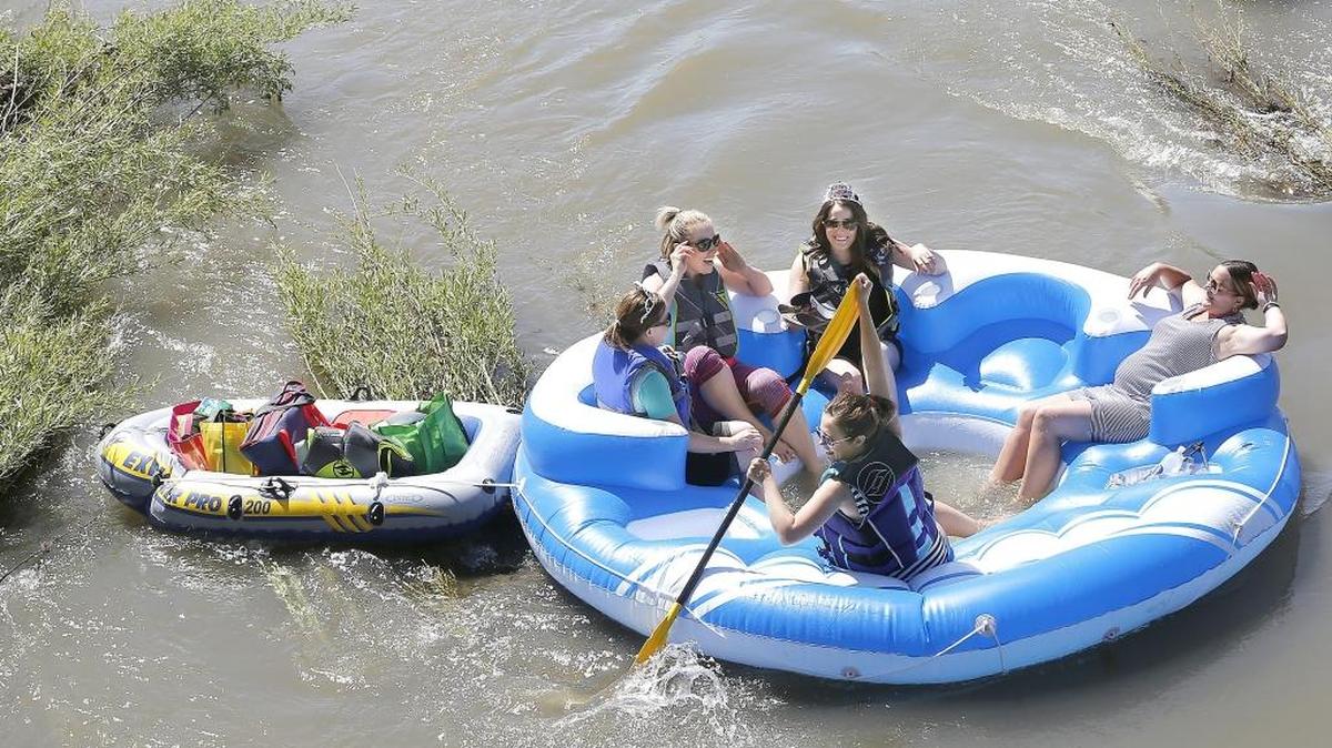 Chelsea Andros gets the party under way Monday paddling a party-size tube down the Yakima River near the West Richland bridge for a float trip to the Chamna Nature Preserve in Richland. The five were celebrating the birthdays of Jessie Nielson, left, and Elise Thompson, who wore tiaras for their special day. Emily Spurgeon, seated between them, and Kaylee Smith, right, join the celebration. The high, swift water helped them reach their destination in about an hour.