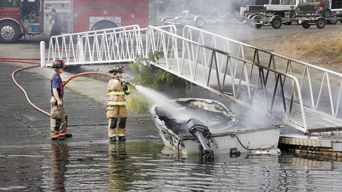 
Richland firefighters spray water on a smoldering boat hull Tuesday afternoon at the Snyder Street boat launch in Richland. Salmon fisherman Greg Mitchell of Richland said he heard popping noises and then an explosion, that blew the engine cover off the boat's inboard motor, when he tried starting his 18-foot Spectrum aluminum boat. Mitchell and his passenger, Debbi Cox of Pasco, were able to safely step off the burning boat. City officials have temporarily closed the damaged dock, that provides access for two of the three launch lanes, until it can be checked for structural integrity and repairs made.
