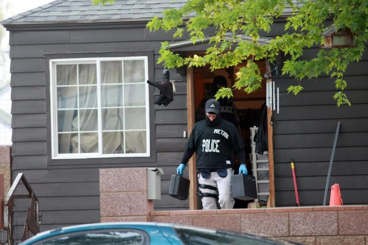 An undercover officer with Tri-Cities Metro Drug Task Force carries evidence out of a home after executing a search warrant in this file photo.