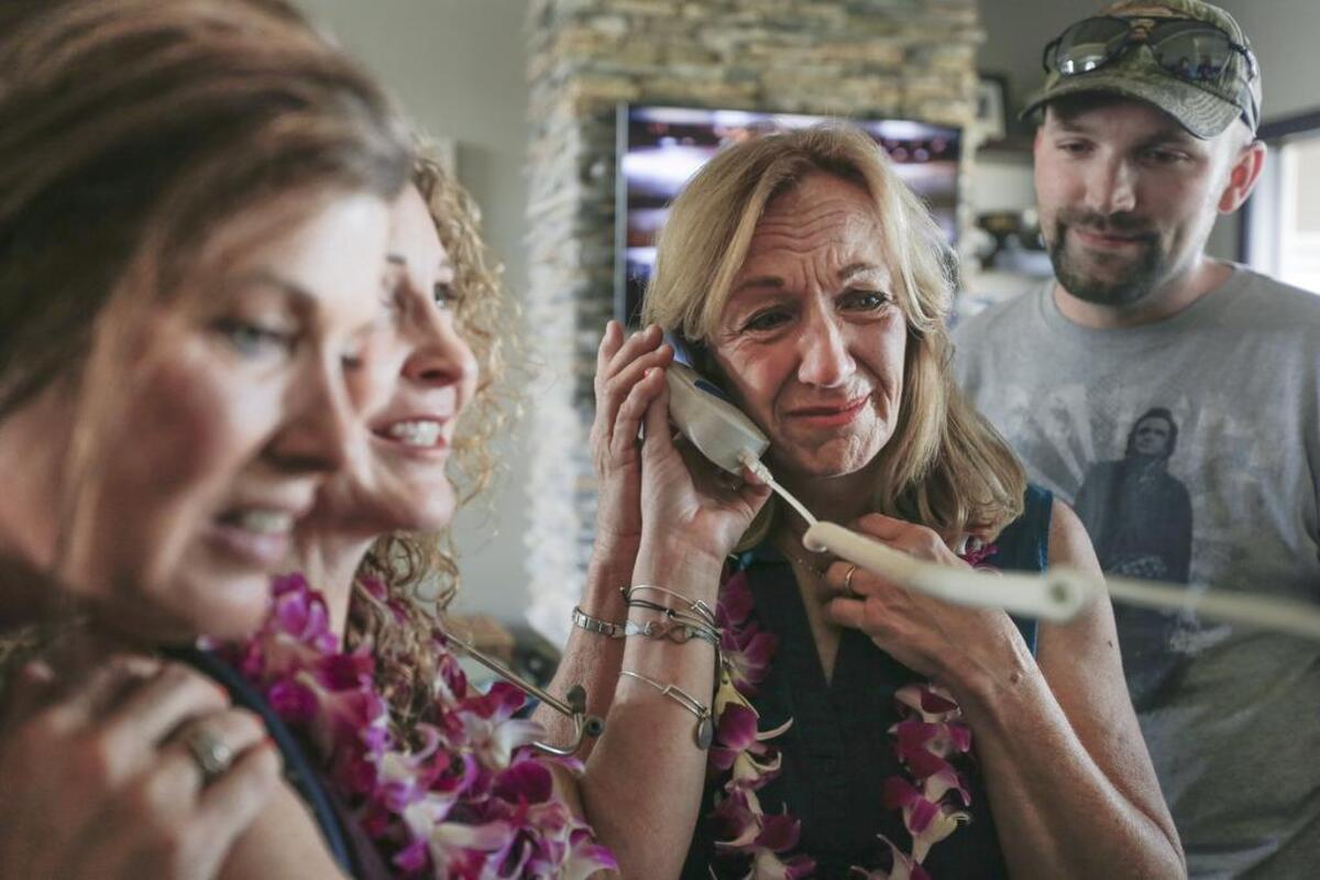 Becky Elzinga, center, listens to her son’s heart beat in Bobby Nakihei’s chest during a gathering in 2017. Nakihei received a heart and kidney from Elzinga’s 20-year-old son.