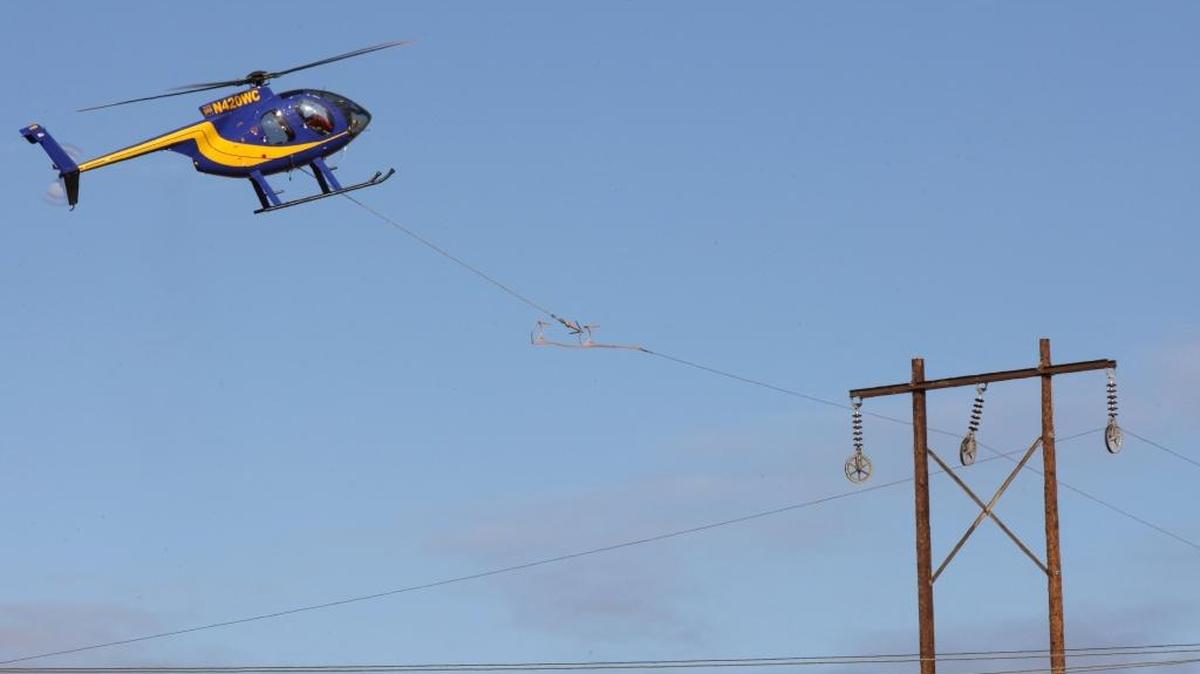 A pilot for Wilson Construction Company of Canby, Ore., works on part of a project to replace aging transmission lines for the Bonneville Power Administration.