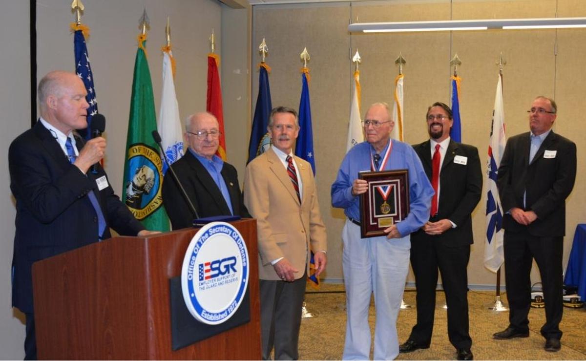 Jim Rabideau holds the James M. Roche Spirit of Volunteerism Award. To his right are his sons Samuel and Thomas Rabideau. He was honored in 2016 for his volunteer work promoting employer support of members of the National Guard and Reserve.